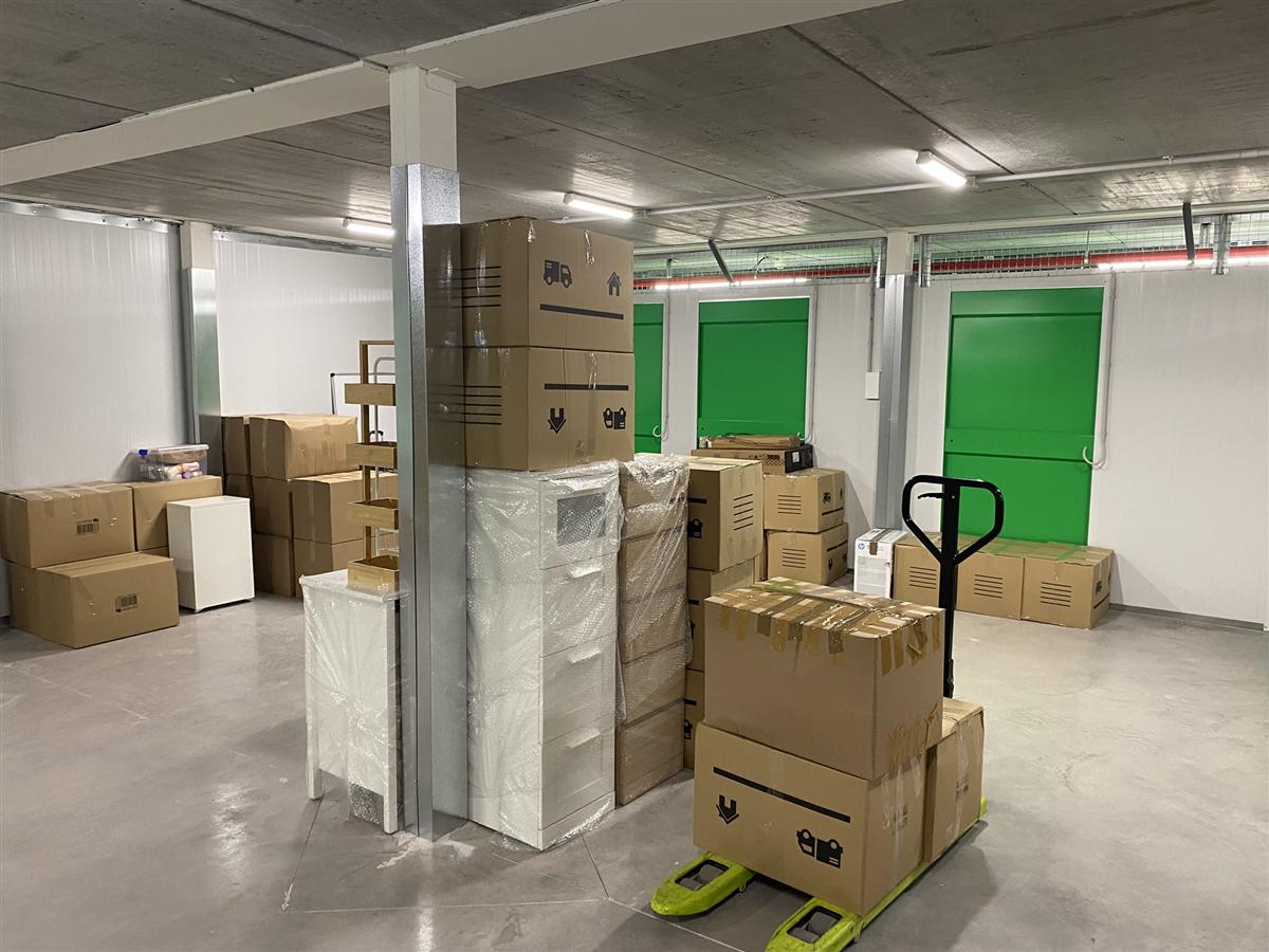 Vista general del almacén de LetsBoxIt con cajas apiladas, estanterías y transpaleta